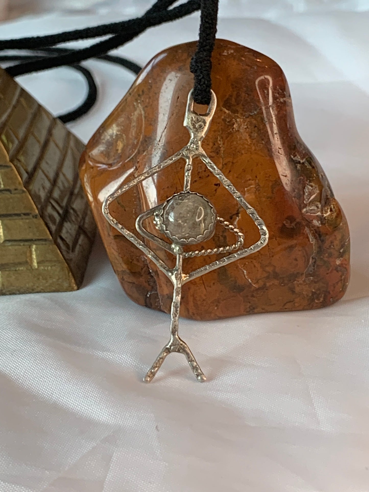 The pendant showcases a Rutilated Quartz cabochon, hand-set in a sterling silver Viking rune-inspired design.