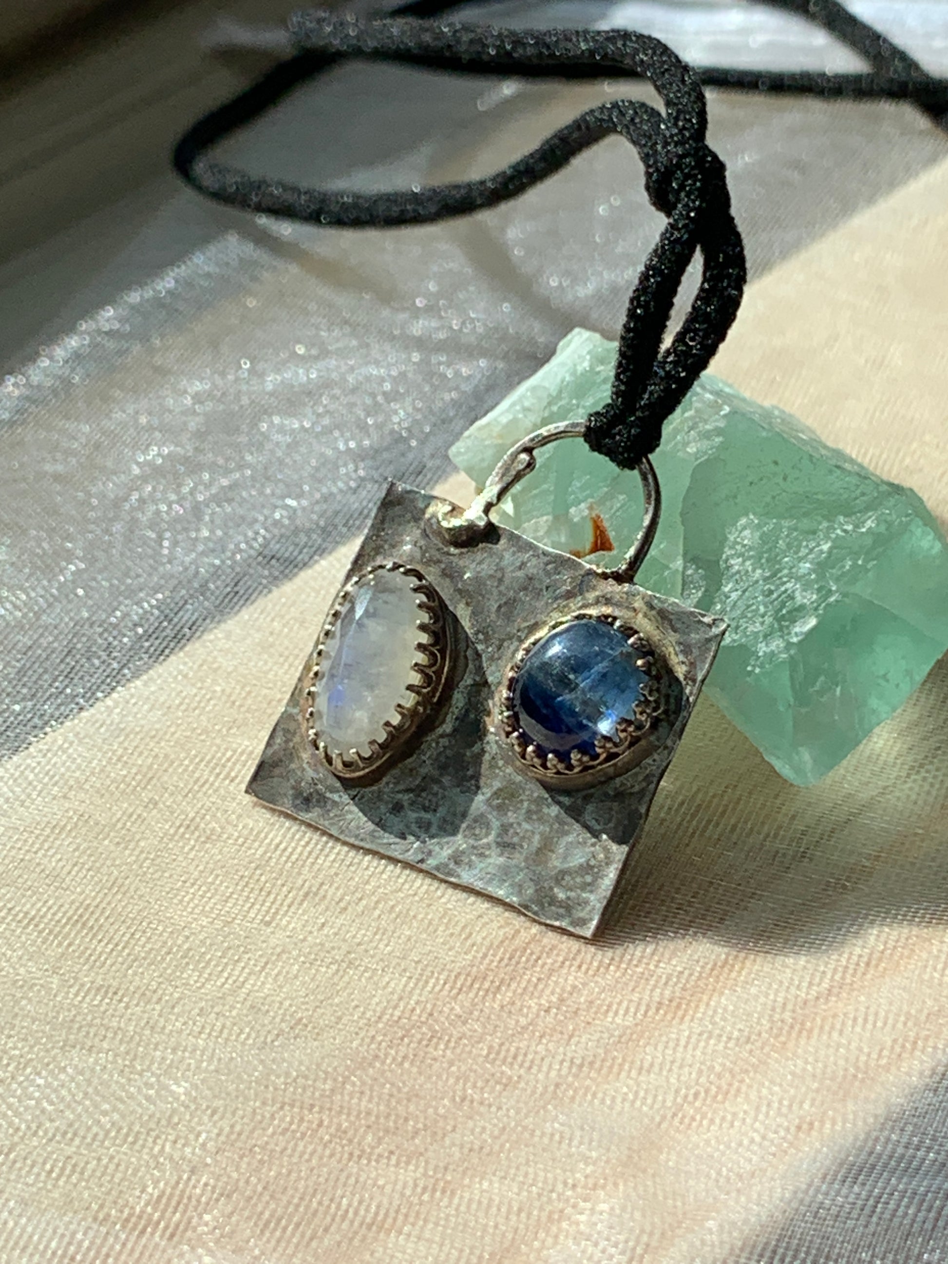 Embrace the fusion of elegance and mystique with our Hammered Oxidized Geometric Blue Kyanite and Rainbow Moonstone Pendant. It's more than just a piece of jewelry; it's a symbol of authenticity, 