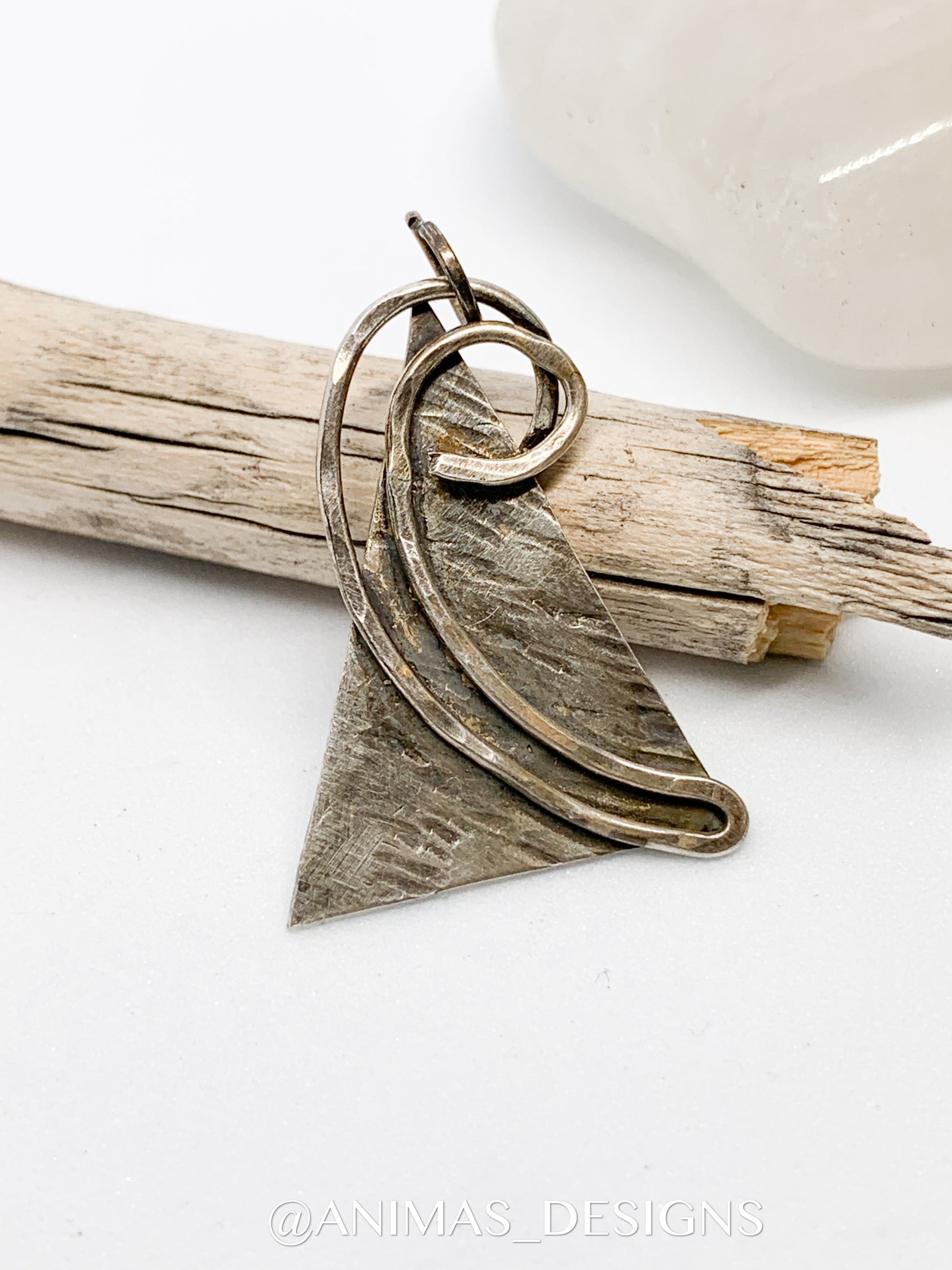 The necklace features a large and fused sterling silver pendant, meticulously handcrafted to create a unique and one-of-a-kind geometric design. 
